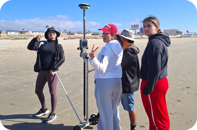 Estudiantes de MACOO realizando trabajo de campo en la playa con equipo de medición